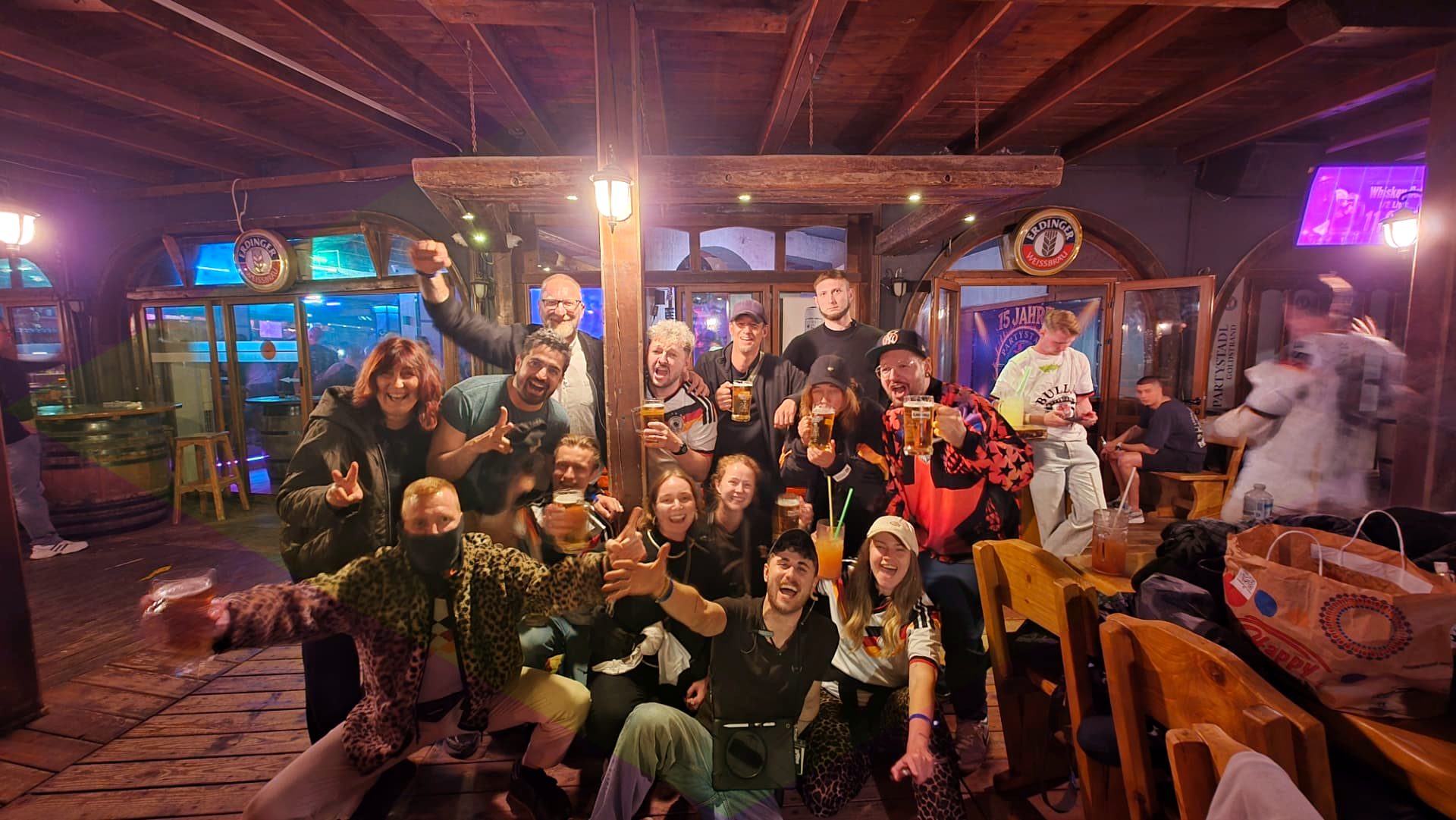 Gruppe feiert am Goldstrand bei Sonnenuntergang mit Party Bus im Hintergrund